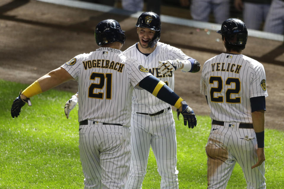 Milwaukee Brewers' Daniel Vogelbach, left, is congratulated by Ryan Braun, center, and Christian Yelich, right, after hitting a three-run home run during the sixth inning of a baseball game against the Kansas City Royals Sunday, Sept. 20, 2020, in Milwaukee. (AP Photo/Aaron Gash)