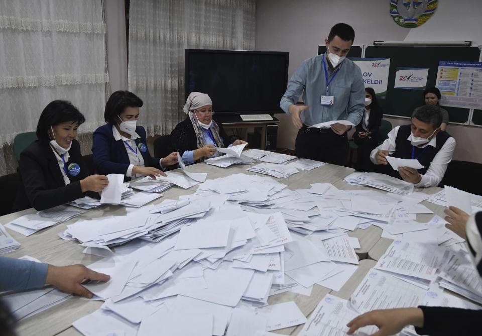 Members of an election commission count ballots at a polling station after the presidential election in Tashkent, Uzbekistan, Sunday, Oct. 24, 2021. Uzbekistan's President, Shavkat Mirziyoyev, who has relaxed many of the policies of his dictatorial predecessor but has made little effort at political reform, is expected to win a new term by a landslide against weak competition in an election Sunday. (AP Photo)