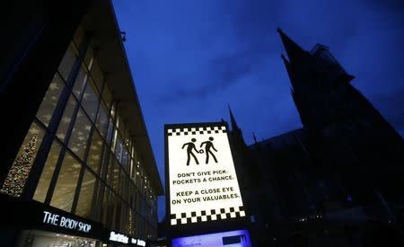 An electronic information sign warning the general public against pickpockets, is illuminated on an advertising board outside the main railway station and in front of Cologne Cathedral in Cologne, Germany, January 5, 2016. REUTERS/Wolfgang Rattay