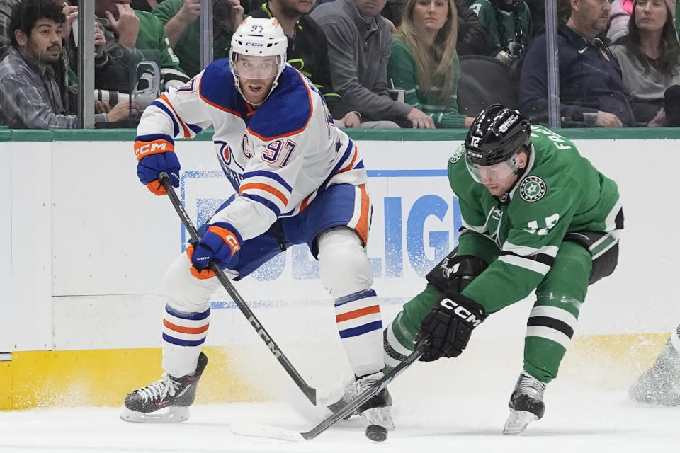 Edmonton Oilers center Connor McDavid (97) and Dallas Stars center Radek Faksa (12) skate for control of the puck during the first period an NHL hockey game in Dallas, Saturday, Feb. 17, 2024. (AP Photo/LM Otero)