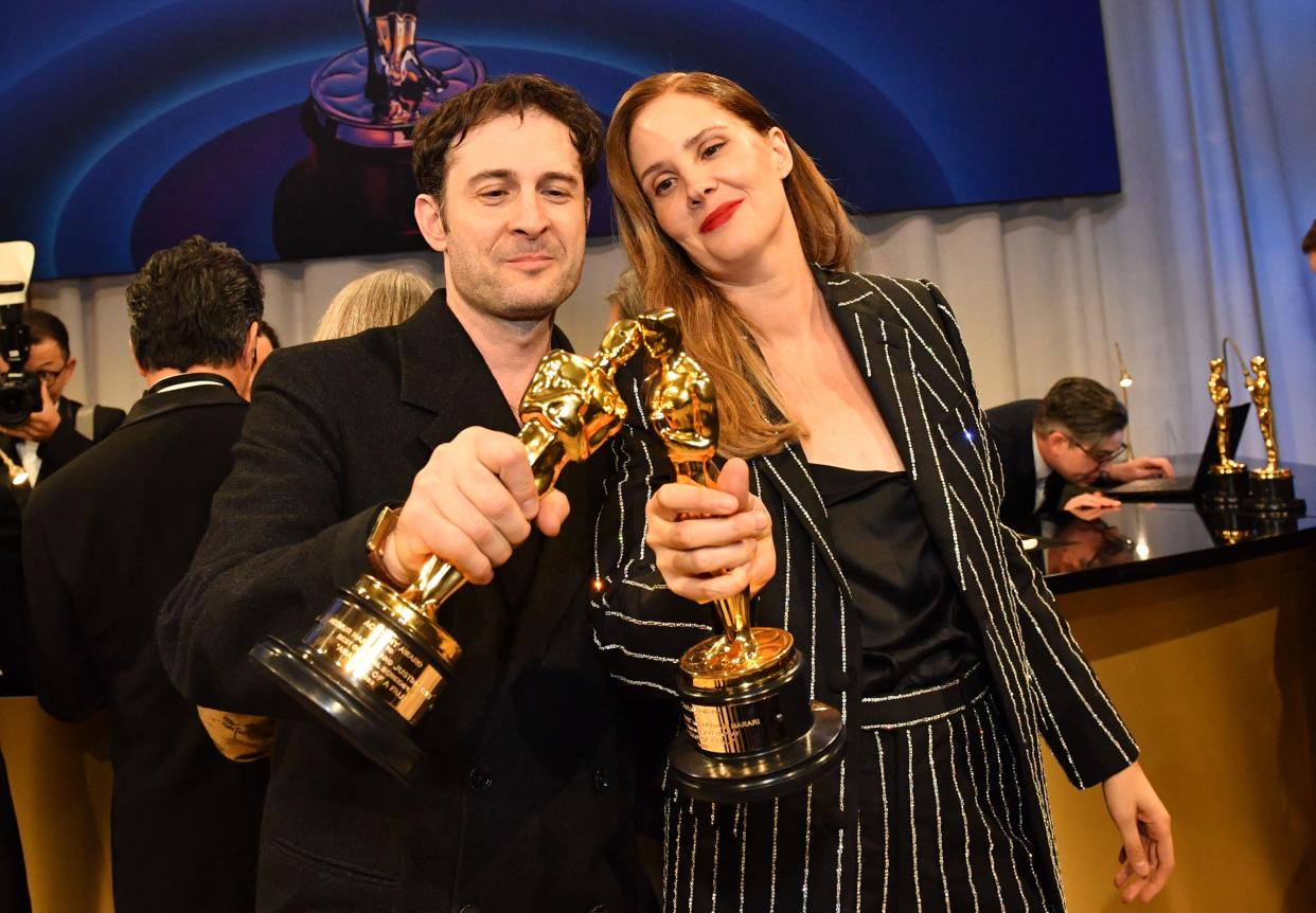 "Anatomy of a Fall" screenwriters Arthur Harari, left, and Justine Triet get their Oscars engraved at the official after-party.