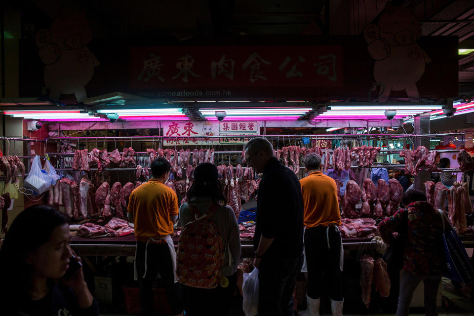 Image: Customers purchase pork from a stall at the Wan Chai wet market in Hong Kong. (Isaac Lawrence / AFP via Getty Images file)
