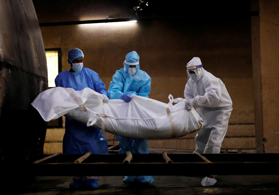 A health worker and relatives wearing personal protective equipment (PPE) carry the body of a man, who died due to the coronavirus disease (COVID-19), for his cremation, at a crematorium in New Delhi, India August 17, 2020. REUTERS/Adnan Abidi     TPX IMAGES OF THE DAY