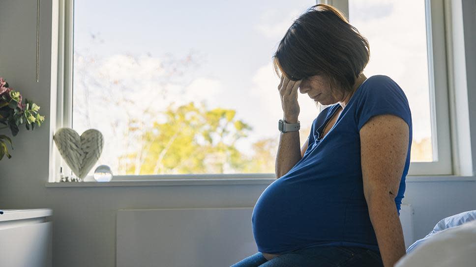 Una mujer embarazada con cara de preocupación 