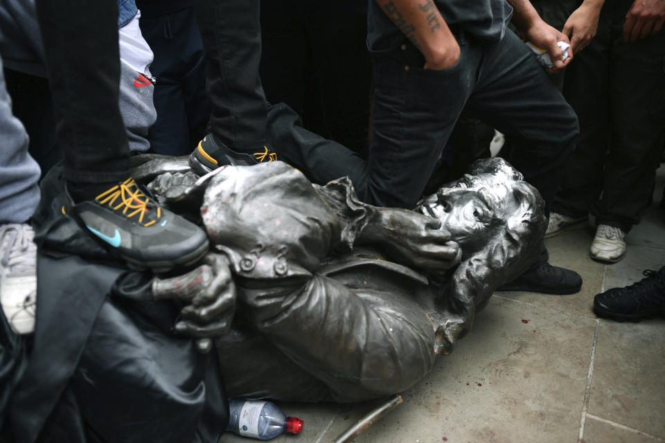 Protesters pull down a statue of slave trader Edward Colston during a Black Lives Matter protest rally on College Green, Bristol, England, Sunday June 7, 2020, in response to the recent killing of George Floyd by police officers in Minneapolis, USA, that has led to protests in many countries and across the US. (Ben Birchall/PA via AP)