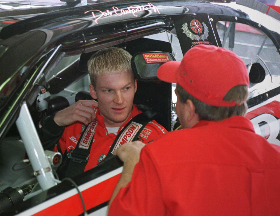 FILE - In this May 5, 1999, file photo, Dale Earnhardt, Jr., of Kannapolis, N.C., left, listens to a crew member as he sits in his Winston Cup race car before a practice session at Lowe's Motor Speedway in Concord, N.C. There’s a pointed episode in Dale Earnhardt Jr.’s television show that encapsulates Earnhardt's remarkable transformation from a bashful third-generation racer into a multimedia personality. (AP Photo/Chuck Burton, File)