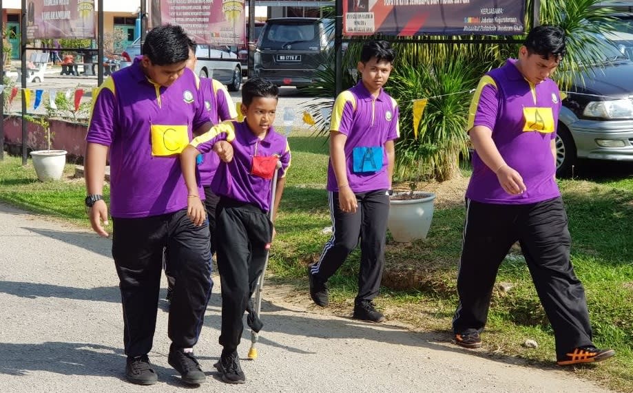 Throughout the entire seven-kilometres, Haikal’s friend walked by his side and helped him complete the course.—Picture via Facebook/SMK Muadzam Shah The Official