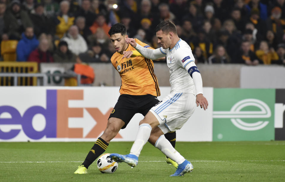 El mexicano del Wolverhampton Wanderers Raúl Jiménez, a la izquierda, disputa un balón con Vasil Bozhikov, del Slovan Bratislava en Wolverhampton, Inglaterra, el jueves 7 de noviembre de 2019. (AP Foto/Rui Vieira)