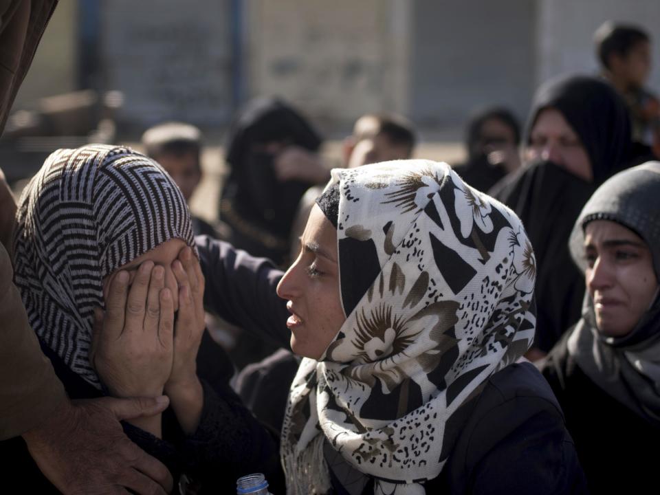 An Iraqi woman comforts a grieving relative at a collection point for displaced citizens of Mosul in this Saturday, Nov. 12, 2016 photo in the Mosul district of Gogjali, Iraq. Residents fleeing the fighting in Mosul say that two years of rule by the Islamic State group crushed a city that was arguably the most multicultural in Iraq with a thriving identity, turning it into a place of darkness and fear. (AP Photo/Nish Nalbandian)