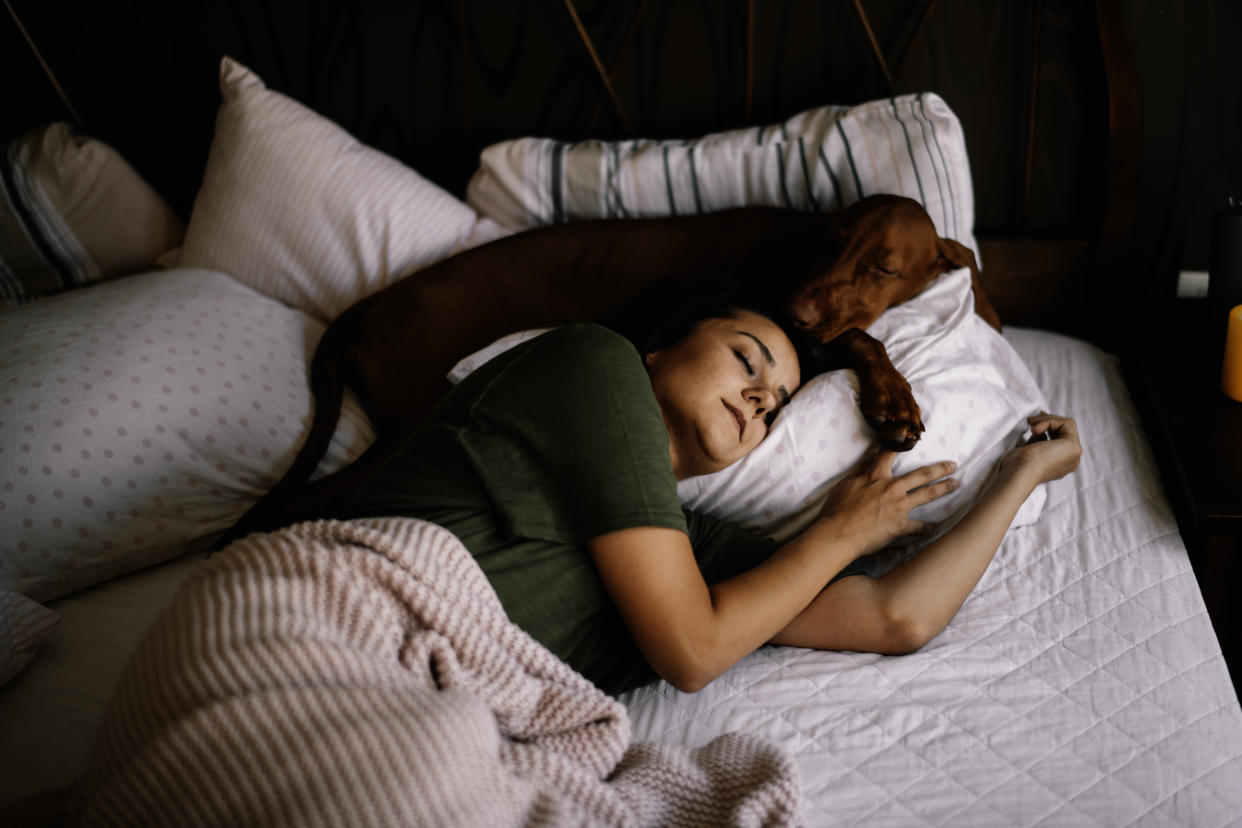 Woman asleep on a bed with her dog