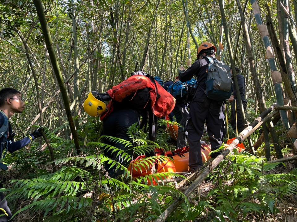 消防人員以捲式擔架搬運待救民眾下山。新北市消防局提供