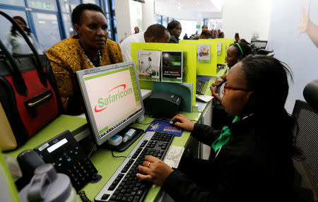 An employee serves a customer inside a mobile phone care centre operated by Kenyan's telecom operator Safaricom; in the central business district of Kenya's capital Nairobi, May 11, 2016. REUTERS/Thomas Mukoya