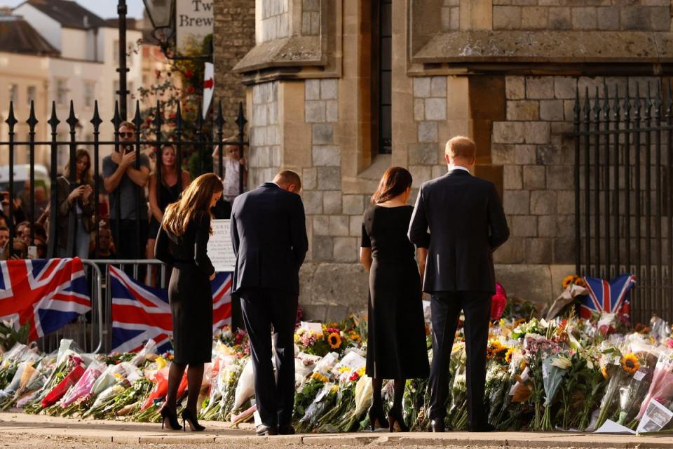 Prince of Wales, Catherine, Princess of Wales, Britain’s Prince Harry and Meghan, the Duchess of Sussex, look at floral tributes as they walk outside Windsor Castle, following the passing of Britain’s Queen Elizabeth, in Windsor (REUTERS)