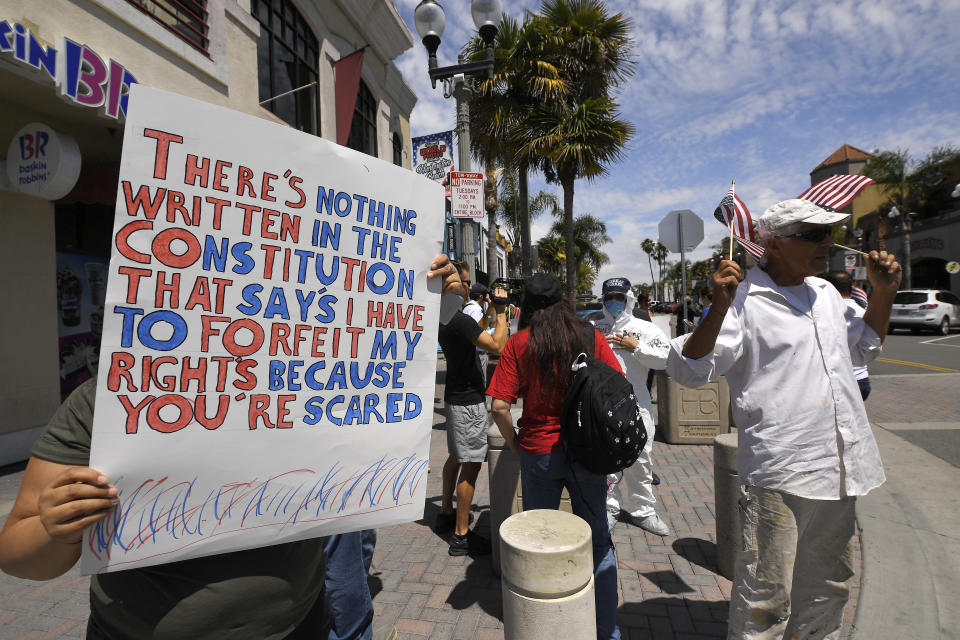 Protesters demonstrate against stay-at-home orders that were put in place due to the COVID-19 outbreak, Friday, April 17, 2020, in Huntington Beach, Calif. (AP Photo/Mark J. Terrill)