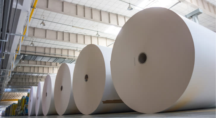 A photo of several large rolls of paper in a warehouse.. RFP stock makes paper products.