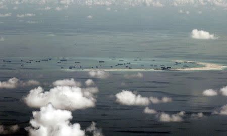 An aerial file photo taken though a glass window of a Philippine military plane shows the alleged on-going land reclamation by China on mischief reef in the Spratly Islands in the South China Sea, west of Palawan, Philippines, in this May 11, 2015 file photo. REUTERS/Ritchie B. Tongo/Pool/Files