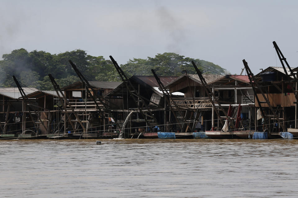 Dredging barges operated by illegal miners converge on the Madeira river, a tributary of the Amazon river, searching for gold, in Autazes, Amazonas state, Brazil, Thursday, Nov.25, 2021. Hundreds of mining barges have arrived during the past two weeks after rumors of gold spread, with environmentalists sounding the alarm about the unprecedented convergence of boats in the sensitive ecosystem. (AP Photo/Edmar Barros)