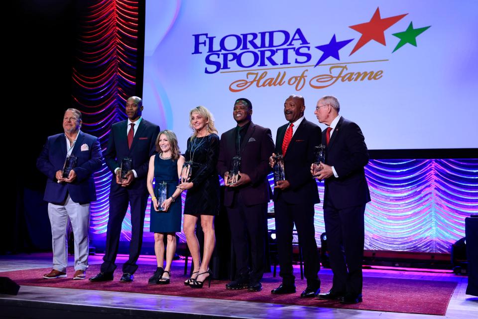 From left, Jeff Johnson, Vince Carter, Shannon Miller, Elaine Larsen, LeRoy Butler, Greg Coleman, and Tom Coughlin pose with their awards during the 2023 Florida Sports Hall of Fame enshrinement ceremony on Nov. 8.