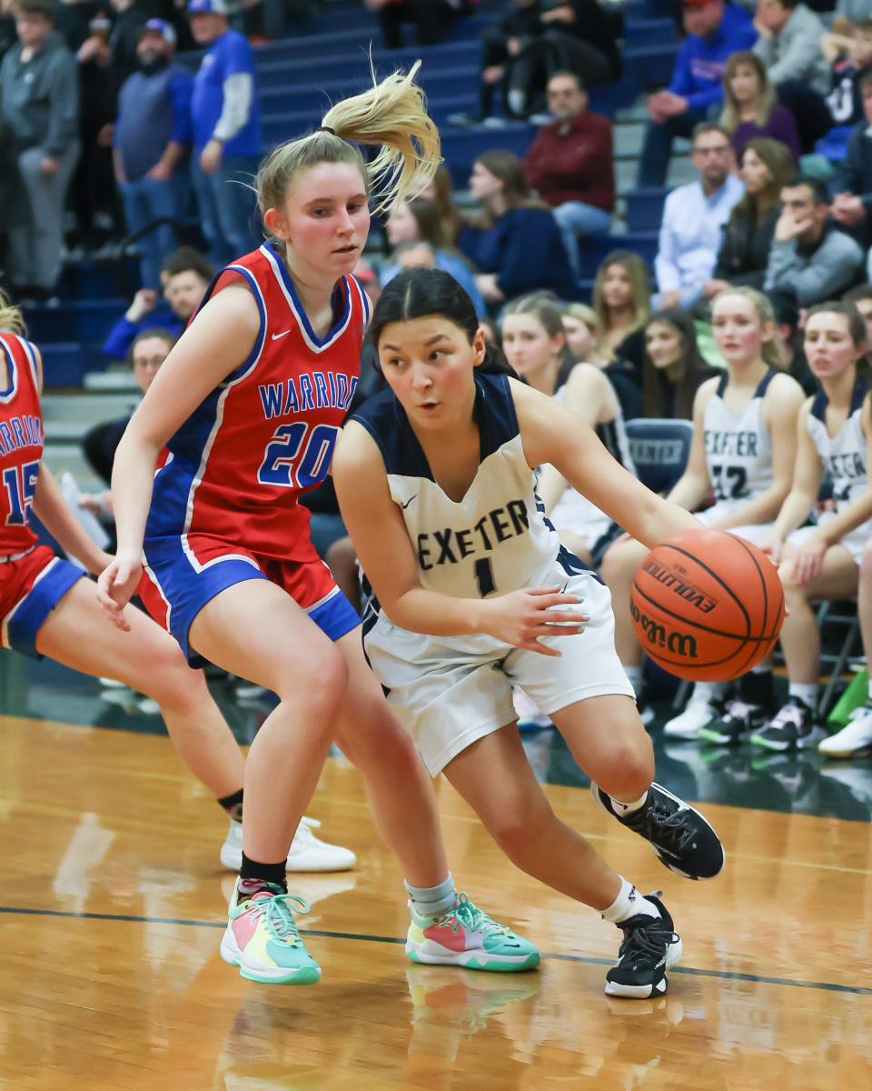 Exeter's Grace Weed drives past Winnacunnet's Riley Kerens during a Division I girls basketball game earlier this season in Exeter.