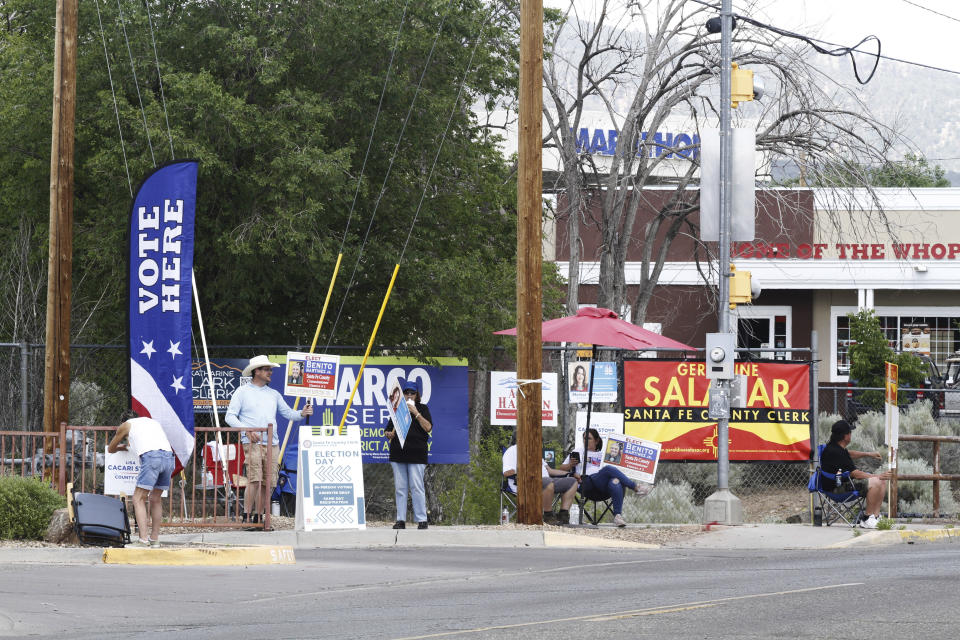 Political campaign supporters greet voters as they turn into a polling location in Santa Fe, N.M., Tuesday, June 4, 2024. New Mexico voters were picking their partisan favorites in the state's primary election to reshape a Democratic-led Legislature, with all 112 seats up for election in November. (AP Photo/Morgan Lee)