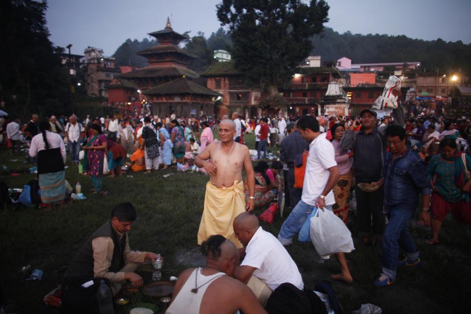 A Nepalese man, center, gets ready to perform rituals during Kuse Aunsi, or Nepalese Fathers Day, at the Gokarneshwar Hindu temple in Katmandu, Nepal, Thursday, Sept. 5, 2013. Kuse Aunsi is a unique Hindu festival of Nepal where fathers living as well as deceased are honored. On this day people perform rituals to pay tributes to their deceased fathers while those with living fathers show their appreciation with presents and sweets. (AP Photo/Niranjan Shrestha)