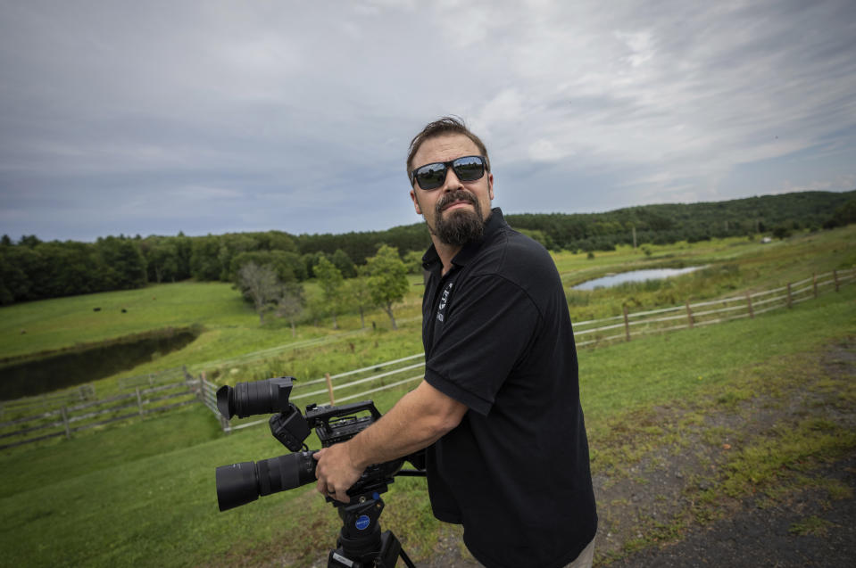 Korey Rowe carga una cámara de video cerca de su casa en Oneonta, Nueva York, el jueves 12 de agosto de 2021. (AP Foto/Robert Bumsted)