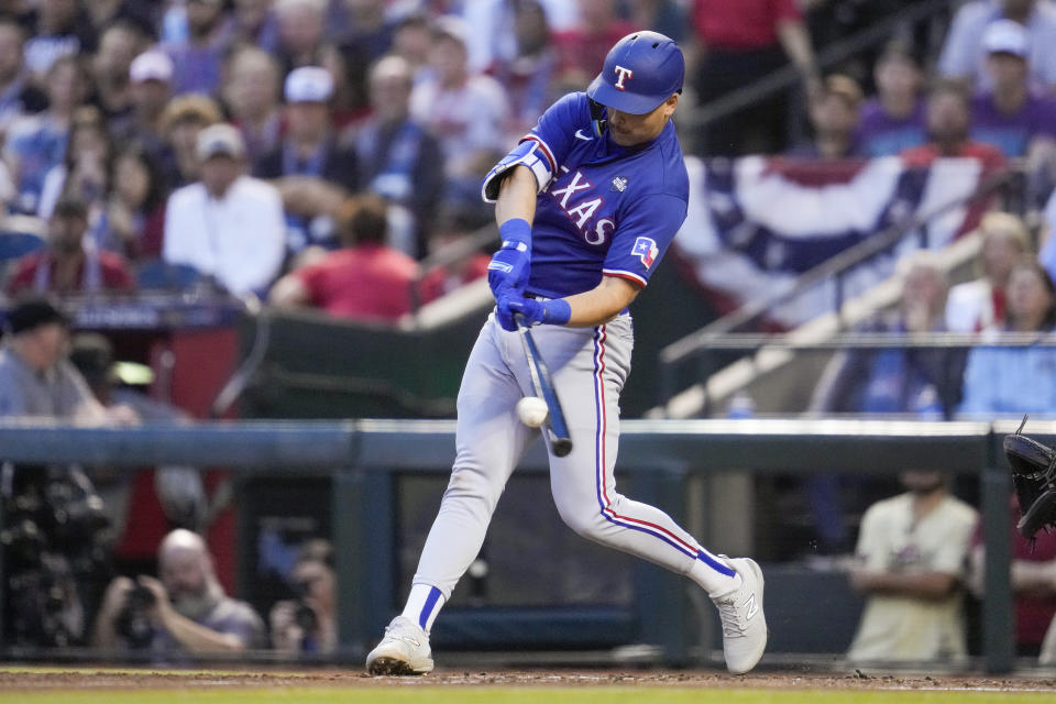 Texas Rangers' Nathaniel Lowe hits a double against the Arizona Diamondbacks during the third inning in Game 3 of the baseball World Series Monday, Oct. 30, 2023, in Phoenix. (AP Photo/Godofredo A. Vásquez)