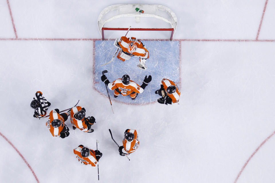 Philadelphia Flyers' Travis Sanheim (6) and Brian Elliott (37) celebrate with teammates after the Flyers won an NHL hockey game against the New Jersey Devils, Monday, May 10, 2021, in Philadelphia. (AP Photo/Matt Slocum)