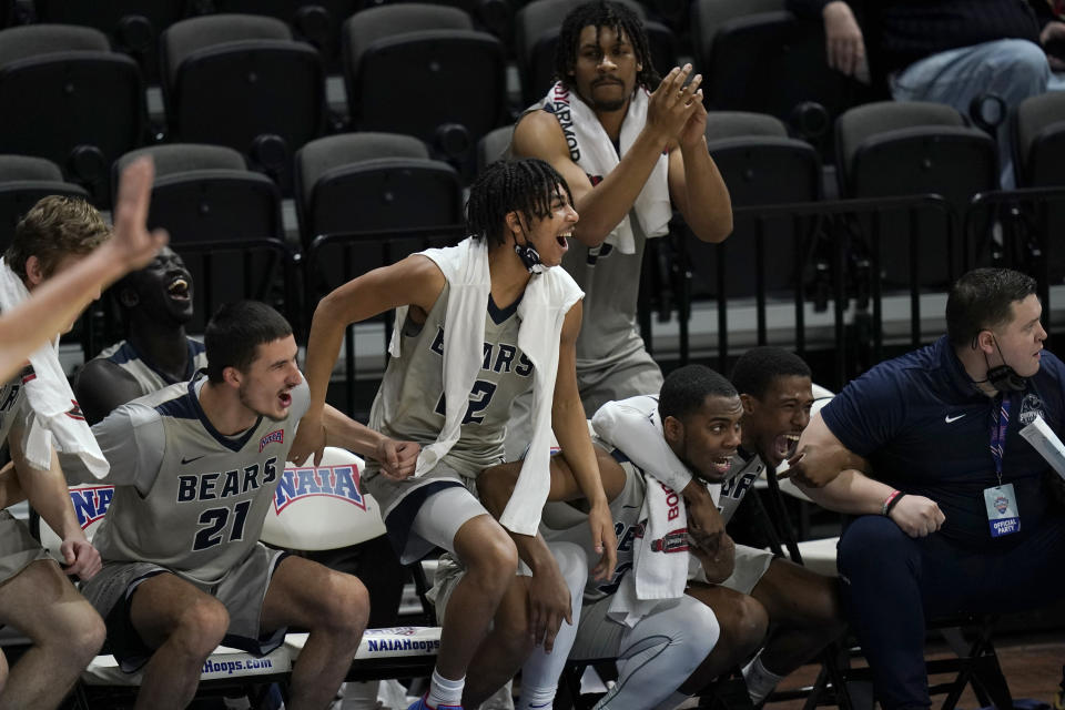 Players on the Shawnee State bench celebrate a basket during the second half of the team's NAIA men's basketball tournament final against Lewis-Clark State in Kansas City, Mo., Tuesday, March 23, 2021. (AP Photo/Orlin Wagner)