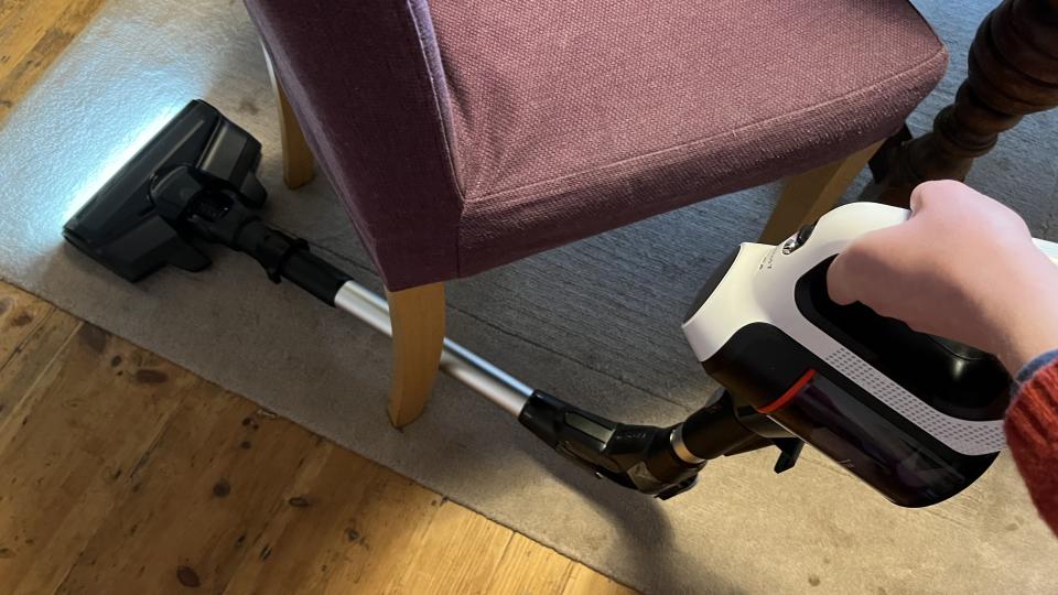 vacuuming under furniture with the flex tube