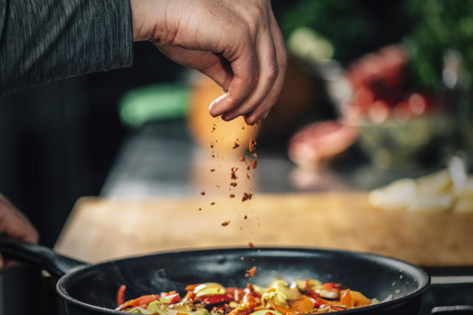 Sprinkling ground paprika over sliced vegetables