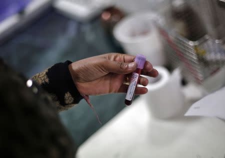 A laboratory staff member holds a patient's blood sample inside a laboratory at Janakpuri Super Speciality Hospital in New Delhi January 19, 2015. REUTERS/Adnan Abidi