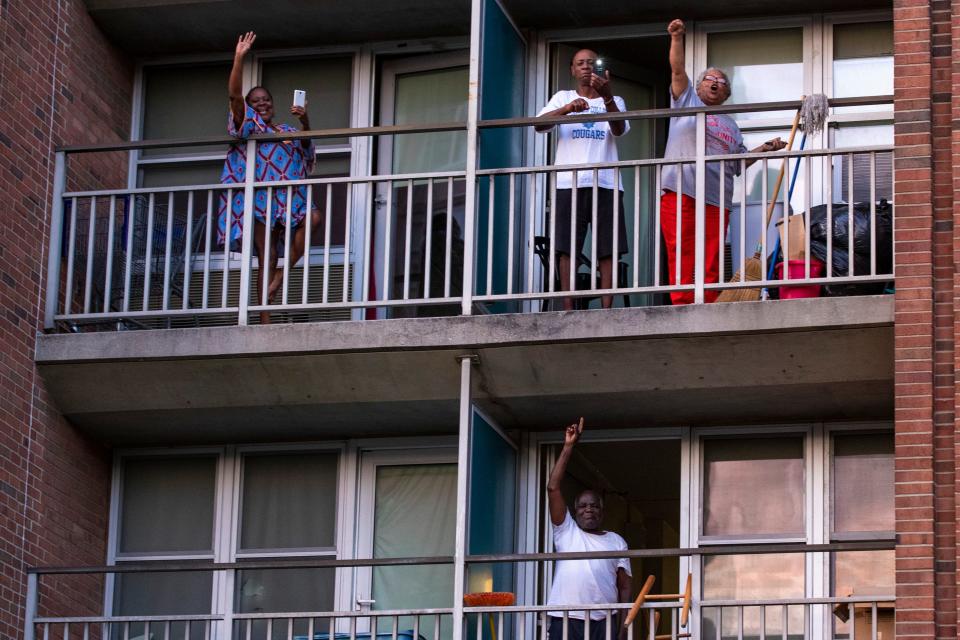 Residents at Dosker Manor look out from balconies as protesters make their way through downtown Louisville during a peaceful protest Tuesday evening. Tuesday marked the 20th straight day of protest in Louisville. June 16, 2020