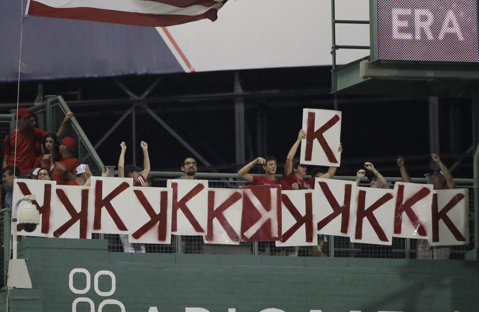 Fans on the Green Monster post a 13th "K" during the eighth inning of a baseball game as they celebrate the number of strikeouts by Boston Red Sox starting pitcher Chris Sale against the Los Angeles Angels at Fenway Park, Thursday, Aug. 8, 2019, in Boston. (AP Photo/Elise Amendola)