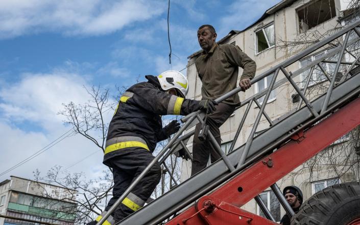 A man is rescued by firefighters after an apartment block was heavily damaged by a missile strike, amid Russia's attack on Ukraine - MARKO DJURICA/REUTERS