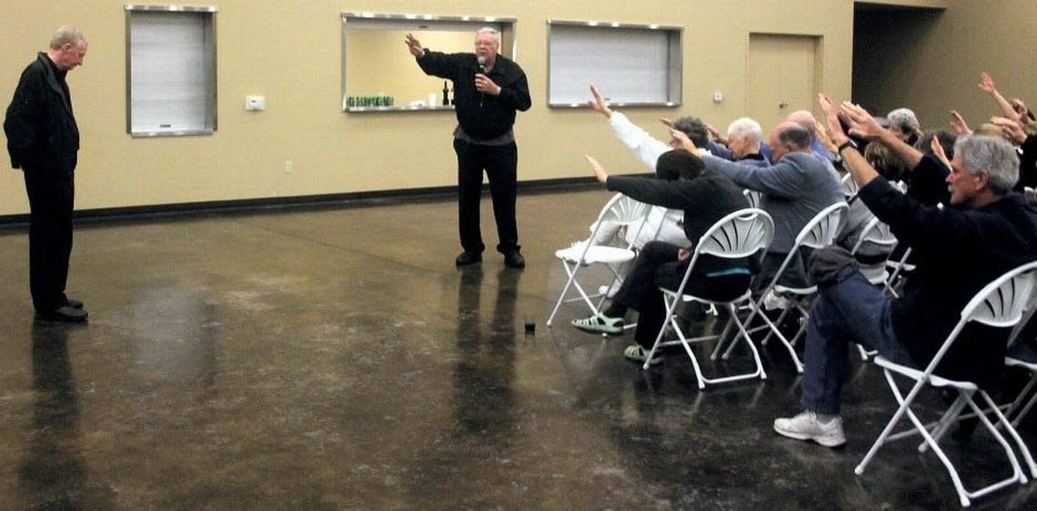 Parishioners stretch their hands out in prayer for Michael Kelly on Friday, April 6, 2012, at St. Joachim Catholic Church in Lockeford, hours after he was found liable in a Calaveras County civil trial of of assault, sexual assault and abuse. Kelly served served as priest at the church since 2004.