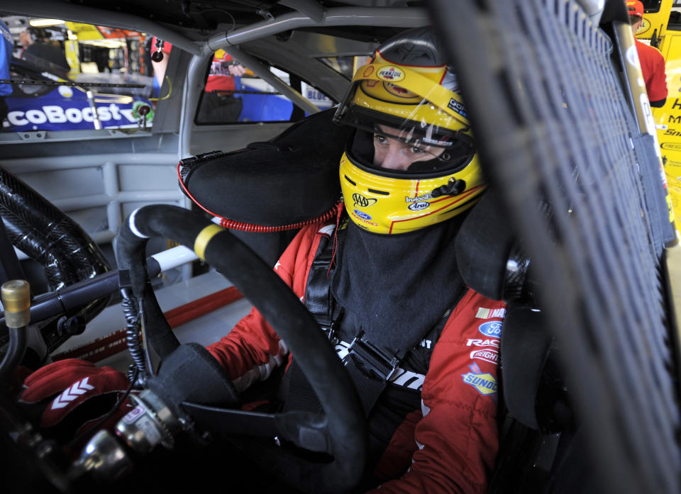 Joey Logano waits in his car before a NASCAR Sprint Cup series auto race practice at Darlington Speedway in Darlington, S.C., Friday, April 11, 2014. (AP Photo/Mike McCarn)