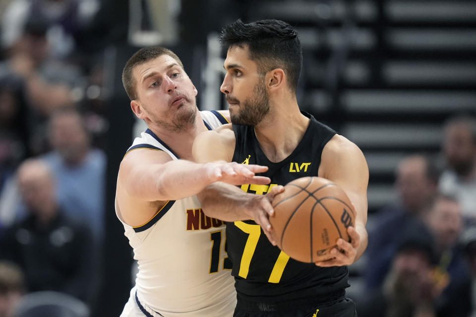 Denver Nuggets center Nikola Jokic, rear, defends against Utah Jazz center Omer Yurtseven (77) during in the first half of an NBA basketball game Tuesday, April 9, 2024, in Salt Lake City. . (AP Photo/Rick Bowmer)