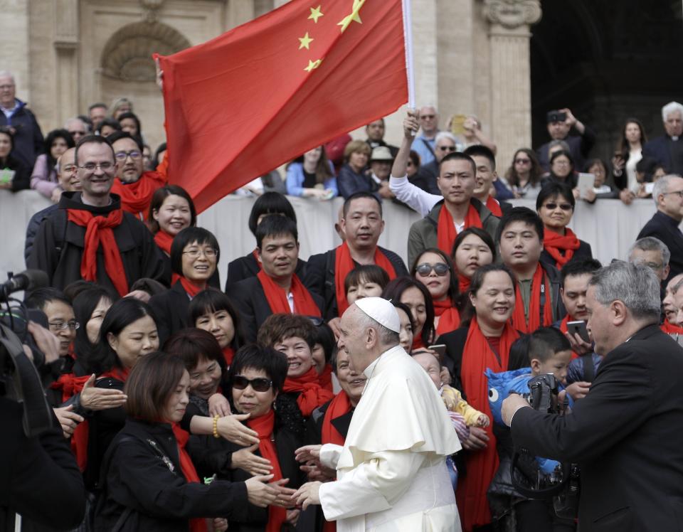 FILE - In this April 18, 2018 file photo, Pope Francis meets a group of faithful from China at the end of his weekly general audience in St. Peter's Square, at the Vatican. The Vatican on Tuesday, Sept. 29, 2020, answered its critics and justified its decision to pursue an extension of an agreement with China over bishop nominations, acknowledging difficulties but insisting that limited, positive results had been achieved.(AP Photo/Gregorio Borgia, file)