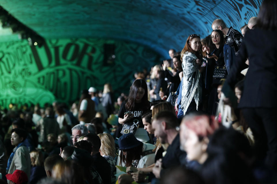 Spectators wait for the Christian Dior pre-fall 2020 men's fashion show to begin during Art Basel on Tuesday, Dec. 3, 2019, in Miami. (AP Photo/Brynn Anderson)