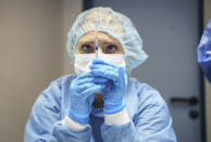 A staff member draws up a syringe with the Pfizer vaccine at the launch of COVID-19 booster vaccinations campaign at the police vaccination centre in Mainz, Germany, Monday, Nov. 29, 2021. (Frank Rumpenhorst/dpa via AP)