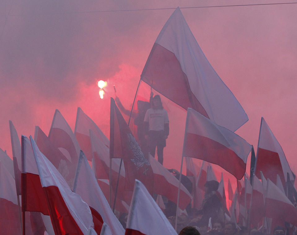 Members of radical right-wing groups light up flares during a march by tens of thousands of people and hosted by President Andrzej Duda that marked 100 years since Poland regained independence in Warsaw, Poland, Sunday, Nov. 11, 2018.(AP Photo/Czarek Sokolowski)