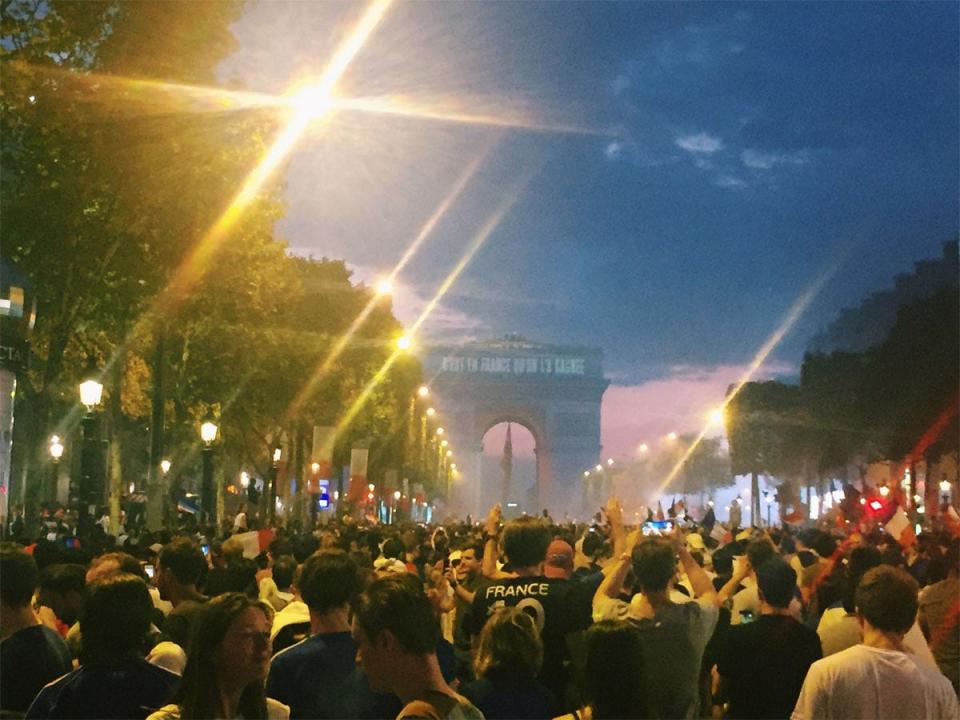 protests in paris with arc de triomphe in the background