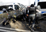 Polish police aim tear gas cannisters at protesters angry over new restrictions aimed at fighting the coronavirus pandemic, in Warsaw, Poland, Saturday, Oct. 24, 2020. The protesters included entrepreneurs, far-right politicians, football fans and vaccine opponents. The protesters, many wearing no protective masks, violated a new restriction on gatherings of more people. The clashes come amid rising social tensions and as new restrictions just short of a full lockdown took effect Saturday. (AP Photo/Czarek Sokolowski)