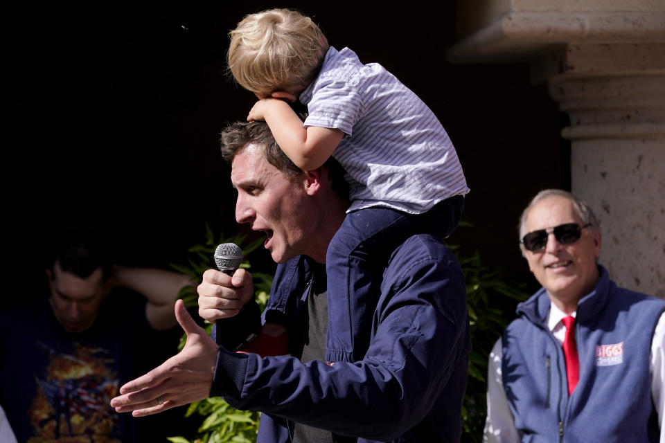 Republican U.S. Senate candidate Blake Masters holds his son, Rex, 2, as he speaks at a rally, Monday, Nov. 7, 2022, in Gilbert, Ariz. (AP Photo/Matt York)