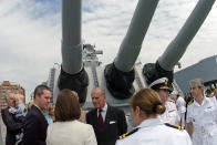 FILE - In this file photo dated Friday, May 4, 2007, Prince Philip of England, center, greets the families of local British military personnel that are attached to the Supreme Allied Command - NATO, located in Norfolk, Va, USA, during a tour of the decommissioned battleship, the U.S.S. Wisconsin. The battleship is berthed alongside Nauticus, a maritime themed museum in Norfolk, Va. Prince Philip who died Friday April 9, 2021, aged 99, lived through a tumultuous century of war and upheavals, but he helped forge a period of stability for the British monarchy under his wife, Queen Elizabeth II. Philip helped create the Commonwealth of nations, with the queen at its head, in an attempt to bind Britain and its former colonies together on a more equal footing.(AP Photo/Gary C. Knapp, FILE)