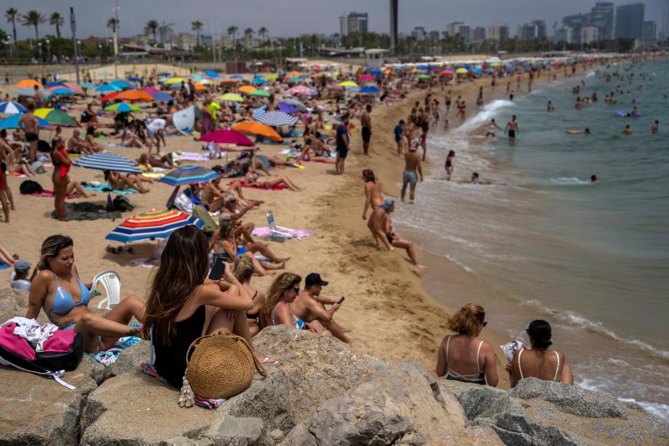 People cool off in the water during warm weather on a beach in Barcelona, Spain, Sunday, June 19, 2022. Temperatures in Western Europe rose above 104 in France and Spain.