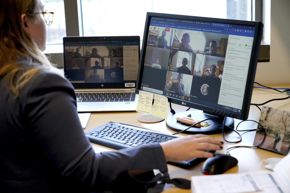 Midshipmen are seen on computer screens as assistant professor Julia Pribyl Ham teaches a foundations of chemistry remote class in her office at the U.S. Naval Academy, Monday, Aug. 24, 2020, in Annapolis, Md. Under the siege of the coronavirus pandemic, classes have begun at the Naval Academy, the Air Force Academy and the U.S. Military Academy at West Point. But unlike at many colleges around the country, most students are on campus and many will attend classes in person. (AP Photo/Julio Cortez)