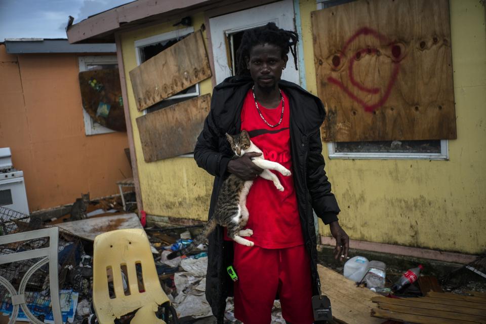 Vladimir Safford, an immigrant from Haiti, poses with his cat next the rubble of his home, in the aftermath of Hurricane Dorian in Abaco, Bahamas, Monday, Sept. 16, 2019. Dorian hit the northern Bahamas on Sept. 1, with sustained winds of 185 mph (295 kph), unleashing flooding that reached up to 25 feet (8 meters) in some areas. (AP Photo/Ramon Espinosa)