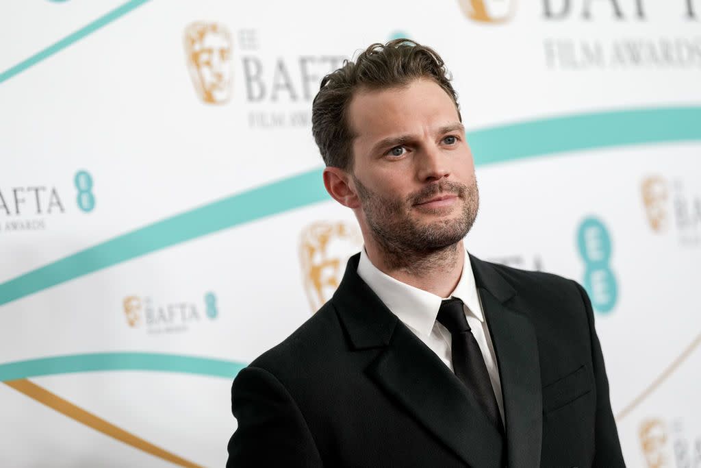 jamie dornan wears a black suit and tie